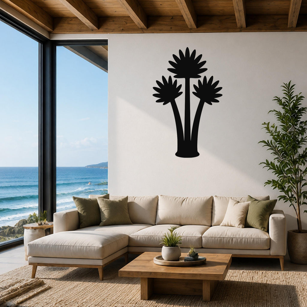 Black metal fan palm tree wall art silhouette mounted on a white living room wall above a beige sectional sofa.