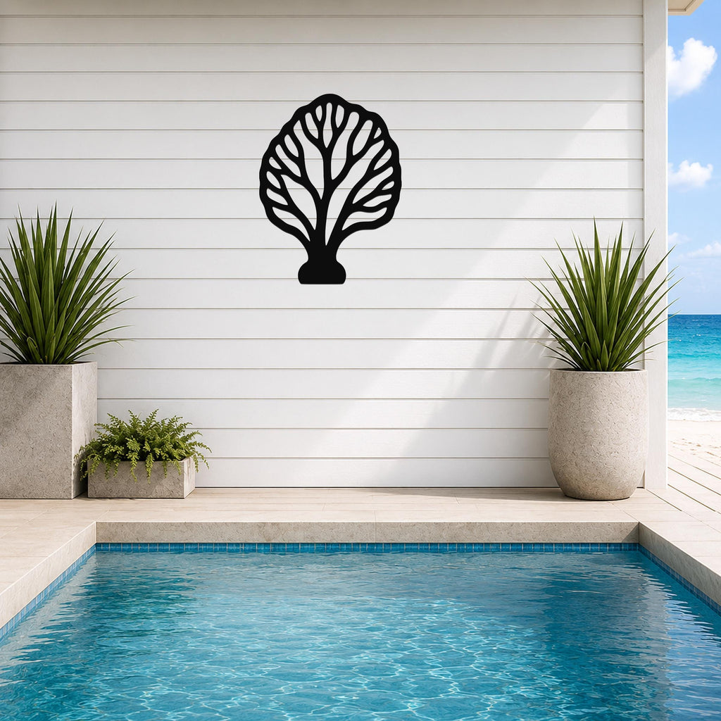 Black metal fan coral wall art with intricate branch cutouts, mounted on a white shiplap wall above a poolside patio.