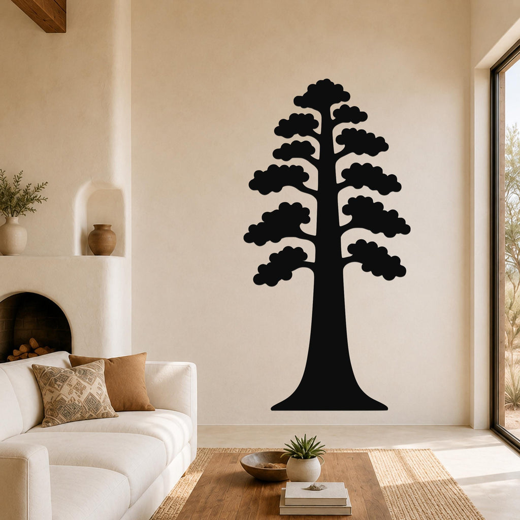 Black metal sequoia tree wall art with layered branch cutouts, mounted on a living room wall above a white sofa.