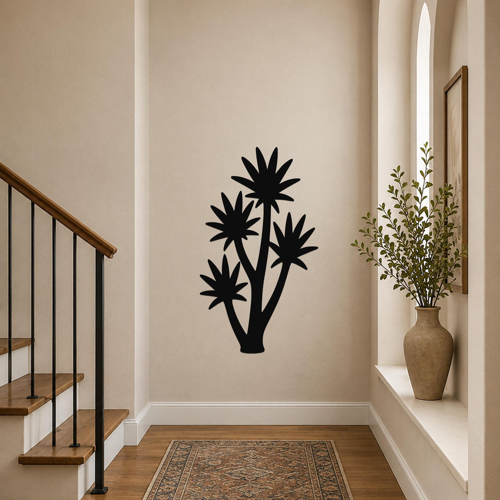 Black metal yucca wall art with multiple star-shaped leaf cutouts, mounted on a hallway wall above a patterned rug near a staircase.