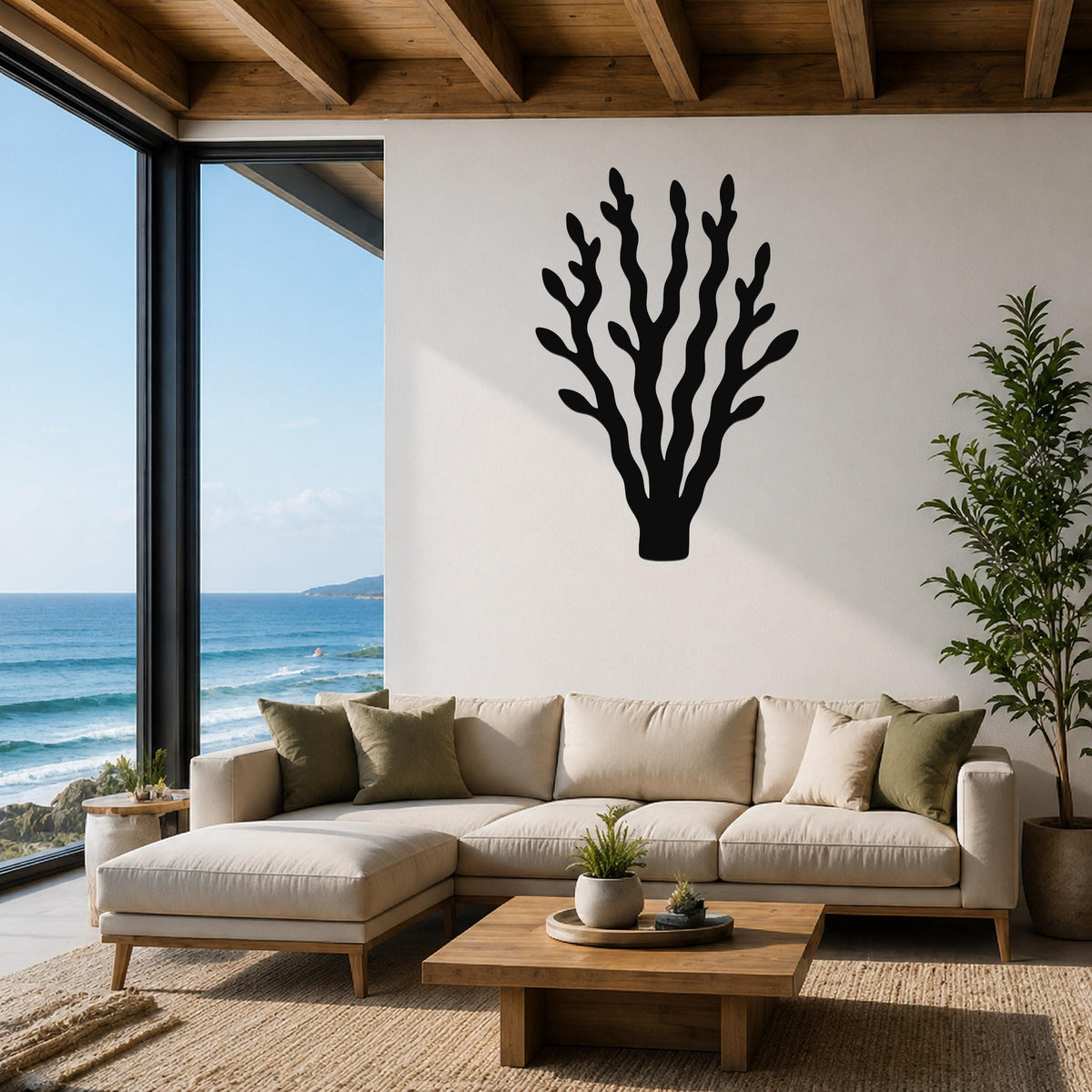 Black metal kelp wall art with branching cutouts, mounted above a beige sectional sofa in a coastal living room with ocean views.