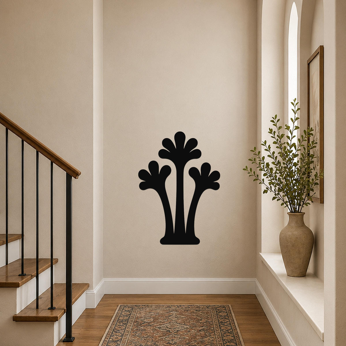 Black metal palm tree wall art with three frond silhouettes, mounted on a hallway wall above a patterned rug near a staircase.