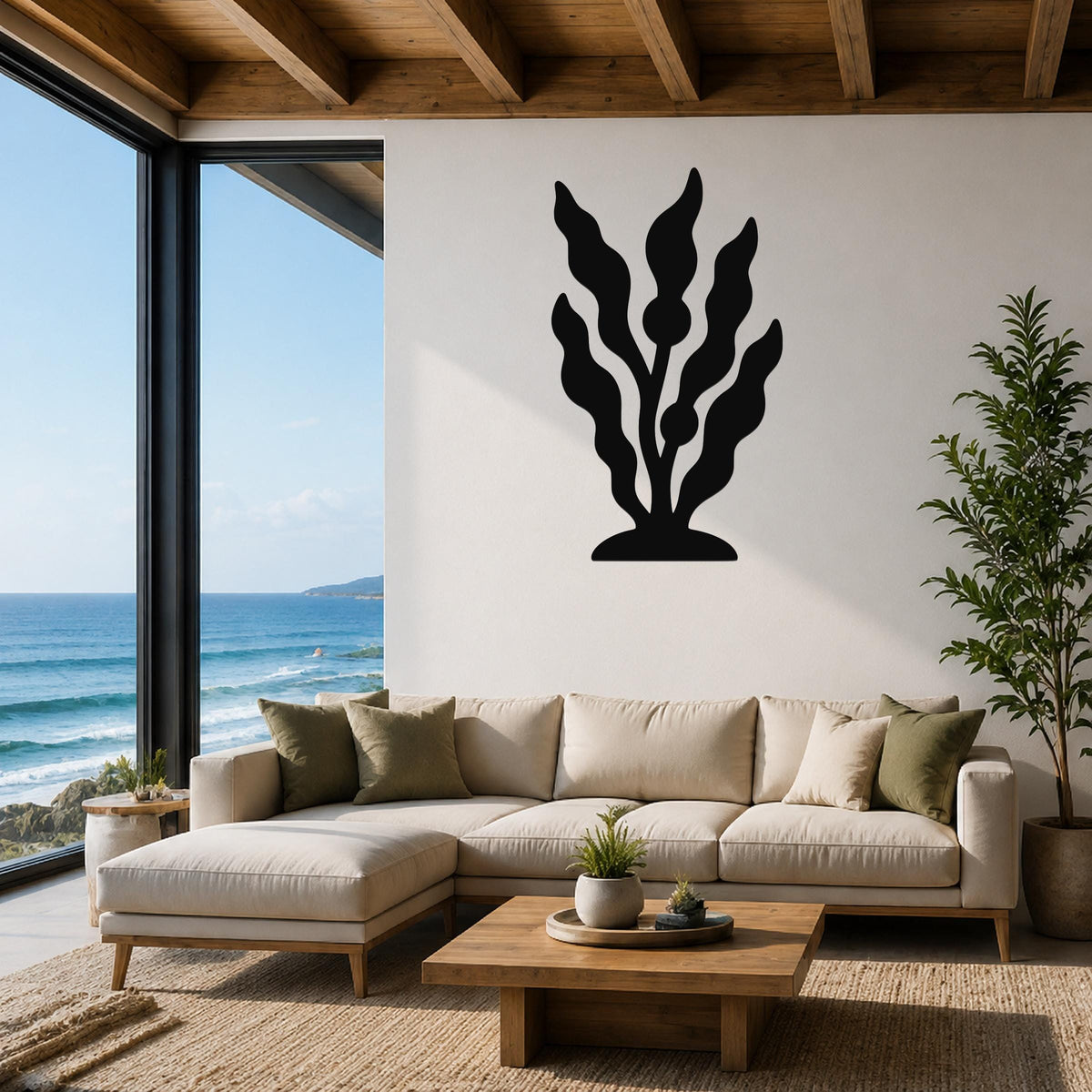 Black metal kelp wall art with flowing leaf cutouts, mounted above a beige sectional sofa in a coastal living room with ocean views.