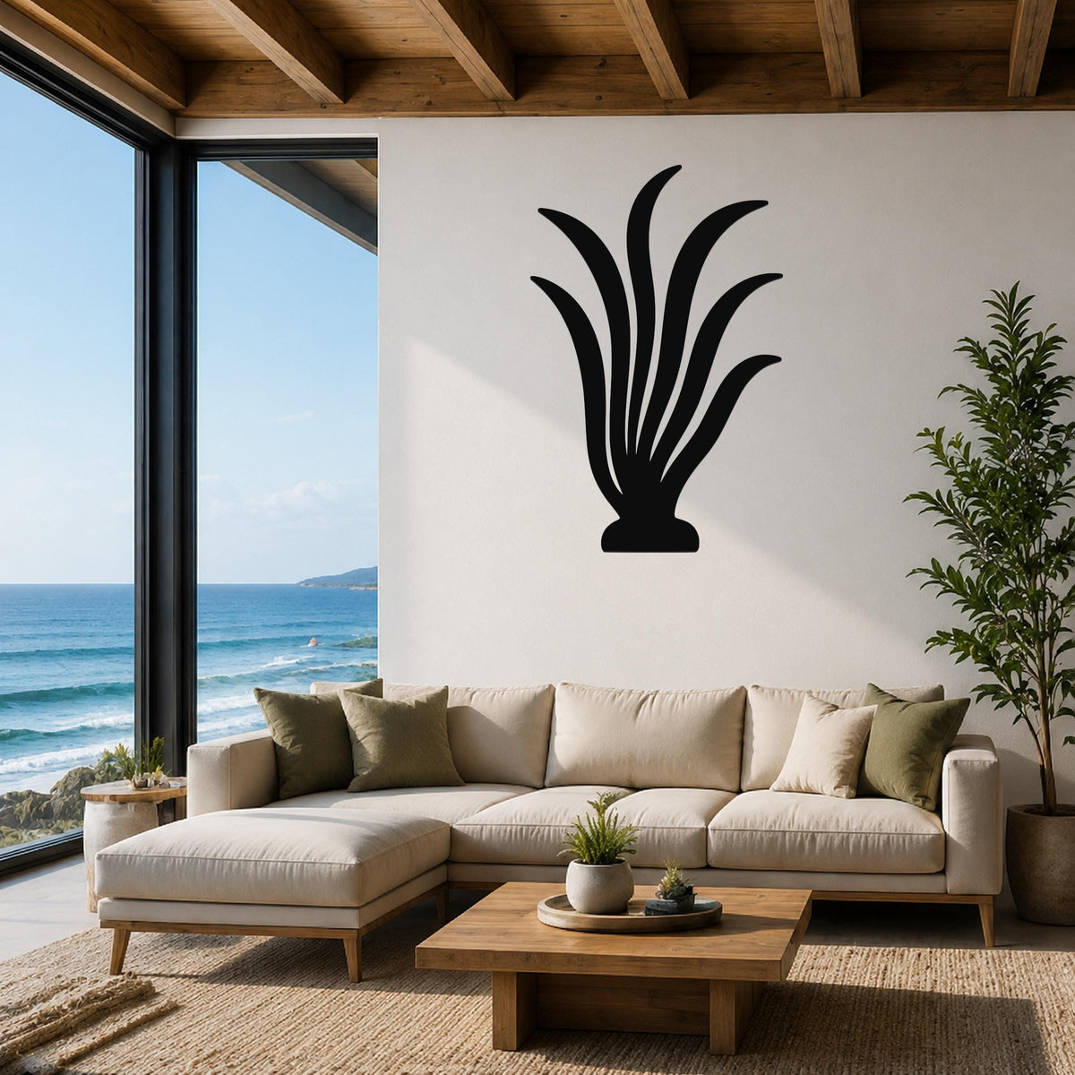 Black metal kelp wall art with flowing leaf cutouts, mounted above a beige sofa in a modern living room with ocean views.