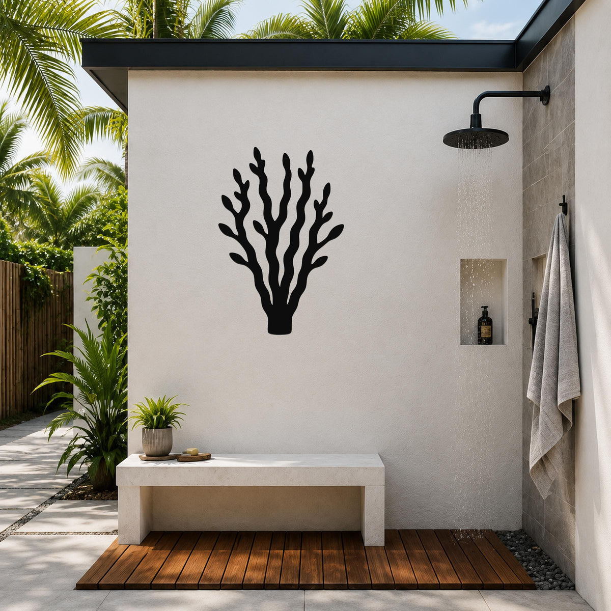 Black metal kelp wall art with branching cutouts, mounted on a white outdoor shower wall above a stone bench.