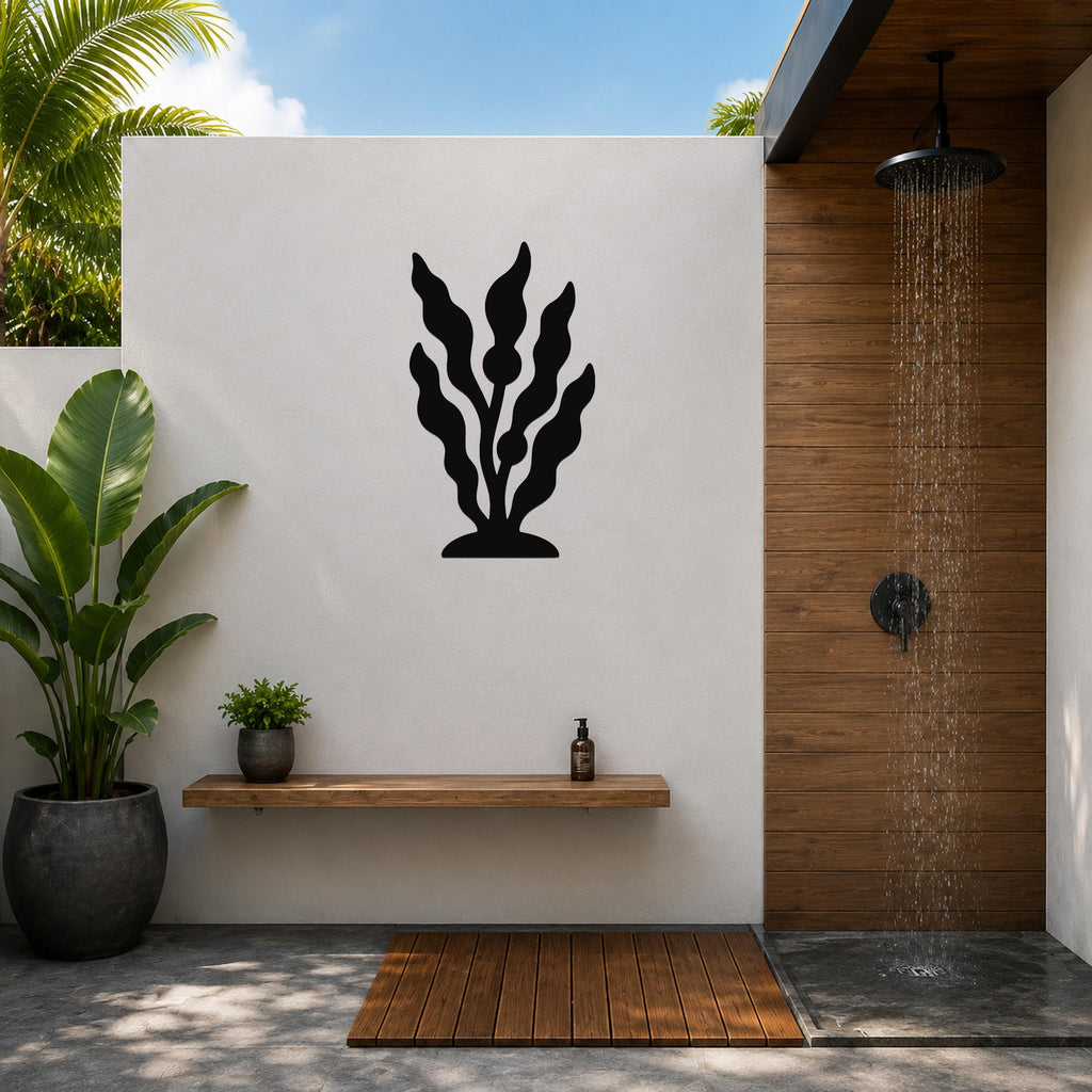 Black metal kelp wall art silhouette mounted on a white outdoor wall above a wooden shelf in a patio shower area.