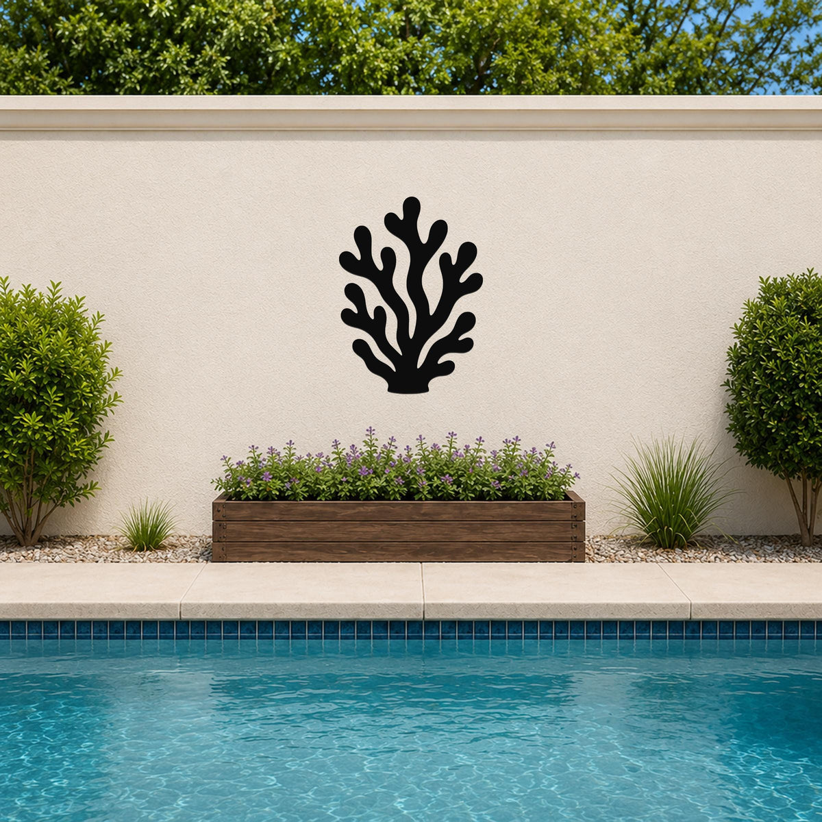 Black metal coral wall art with branching cutouts, mounted on an outdoor wall above a planter and pool.
