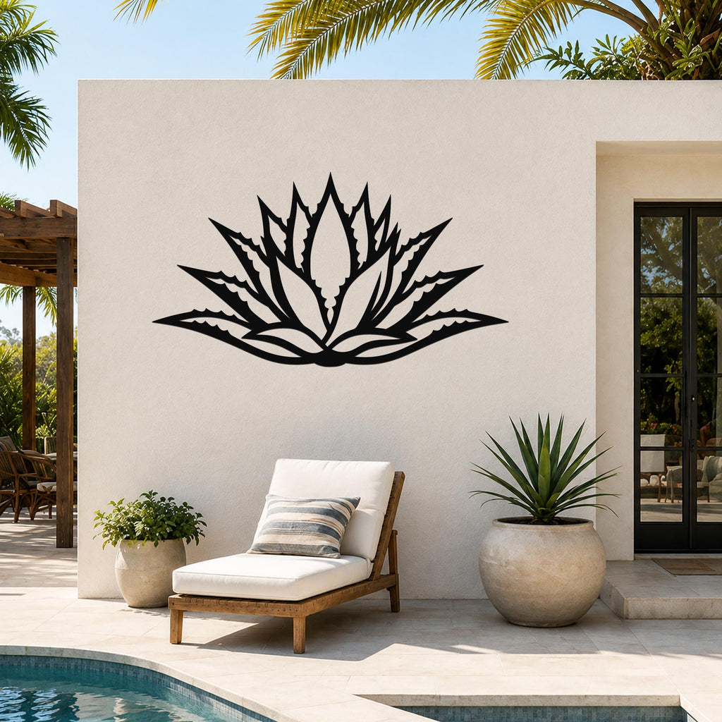 Black metal agave wall art with a bold geometric cutout design, mounted on a white outdoor wall beside a pool and lounge chair.