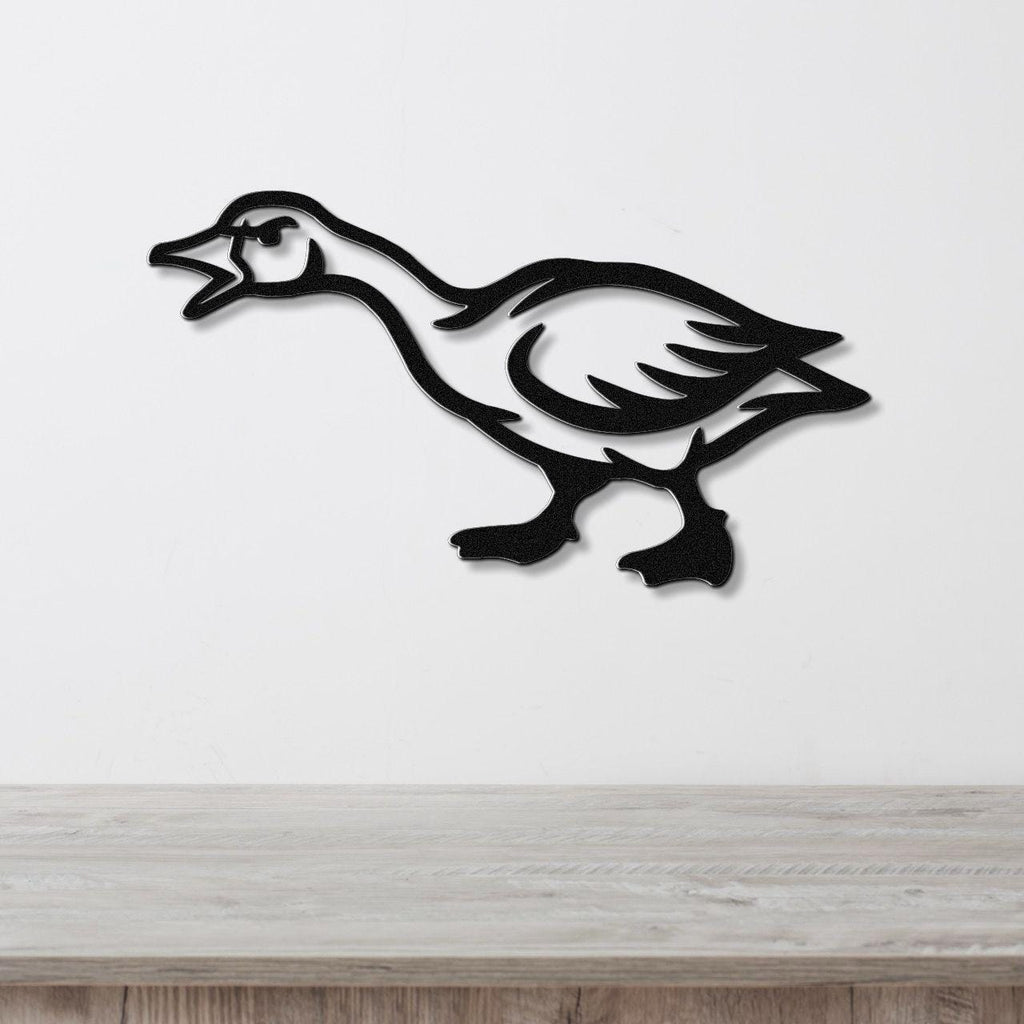 Black metal goose wall art with a silhouette cutout design, mounted on a white wall above a light wood countertop.