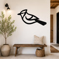 Black metal blue jay wall art silhouette mounted on a white wall above a wooden bench in a entryway.