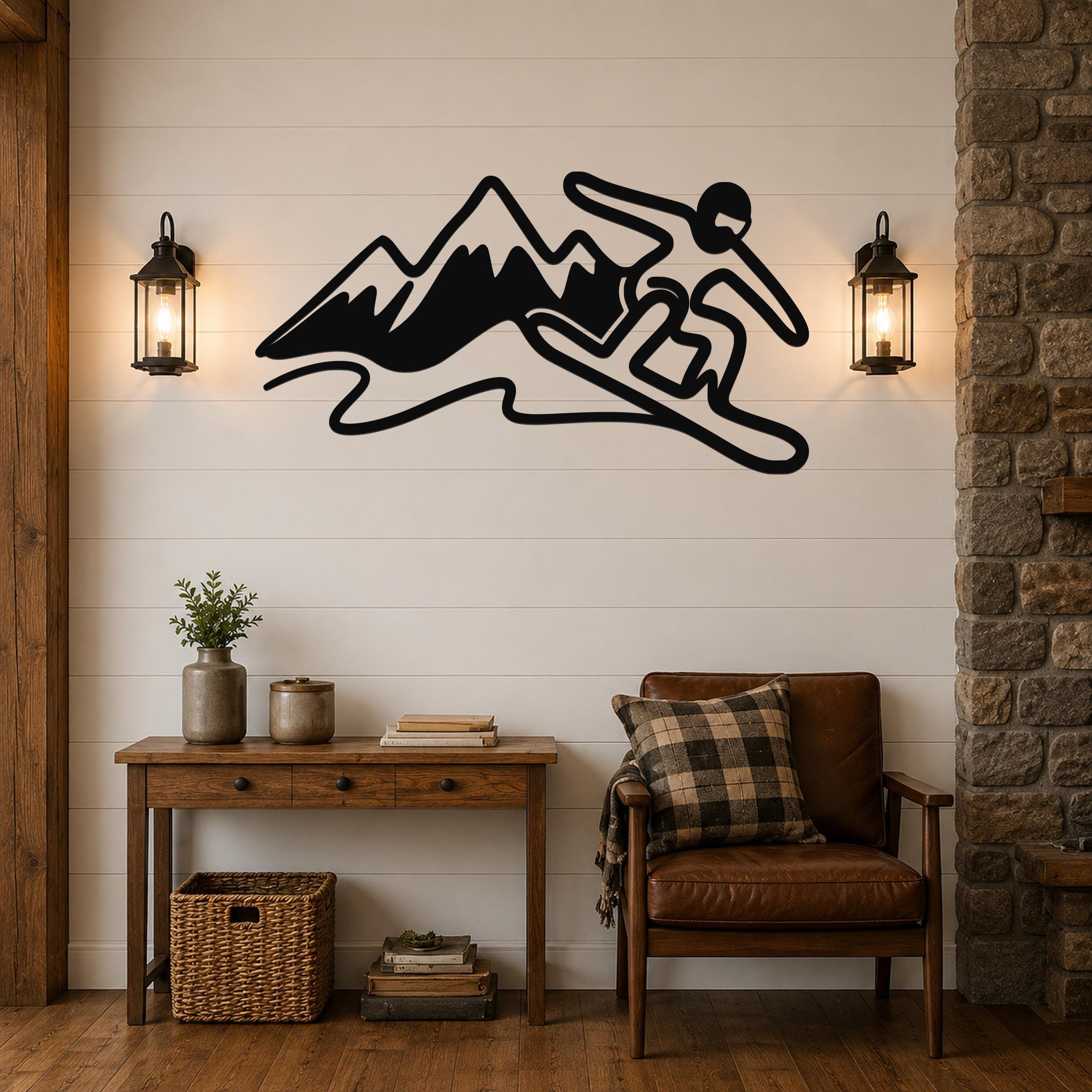 Black metal wall art silhouette of a snowboarder in motion above a mountain range, mounted on a shiplap wall between two lanterns in a living room.