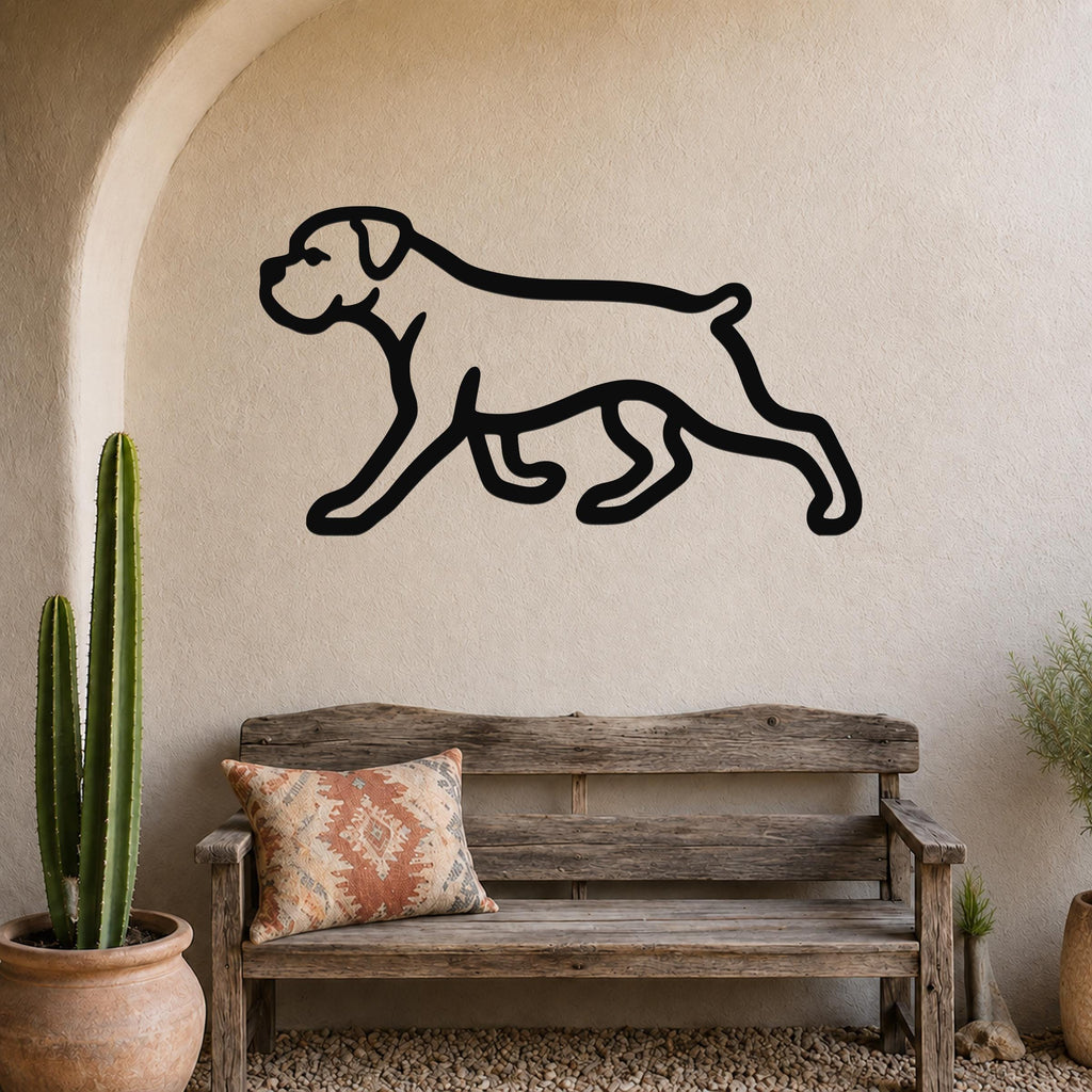 Black metal Boxer dog silhouette wall art mounted on a stucco wall above a wooden bench in a rustic patio setting.