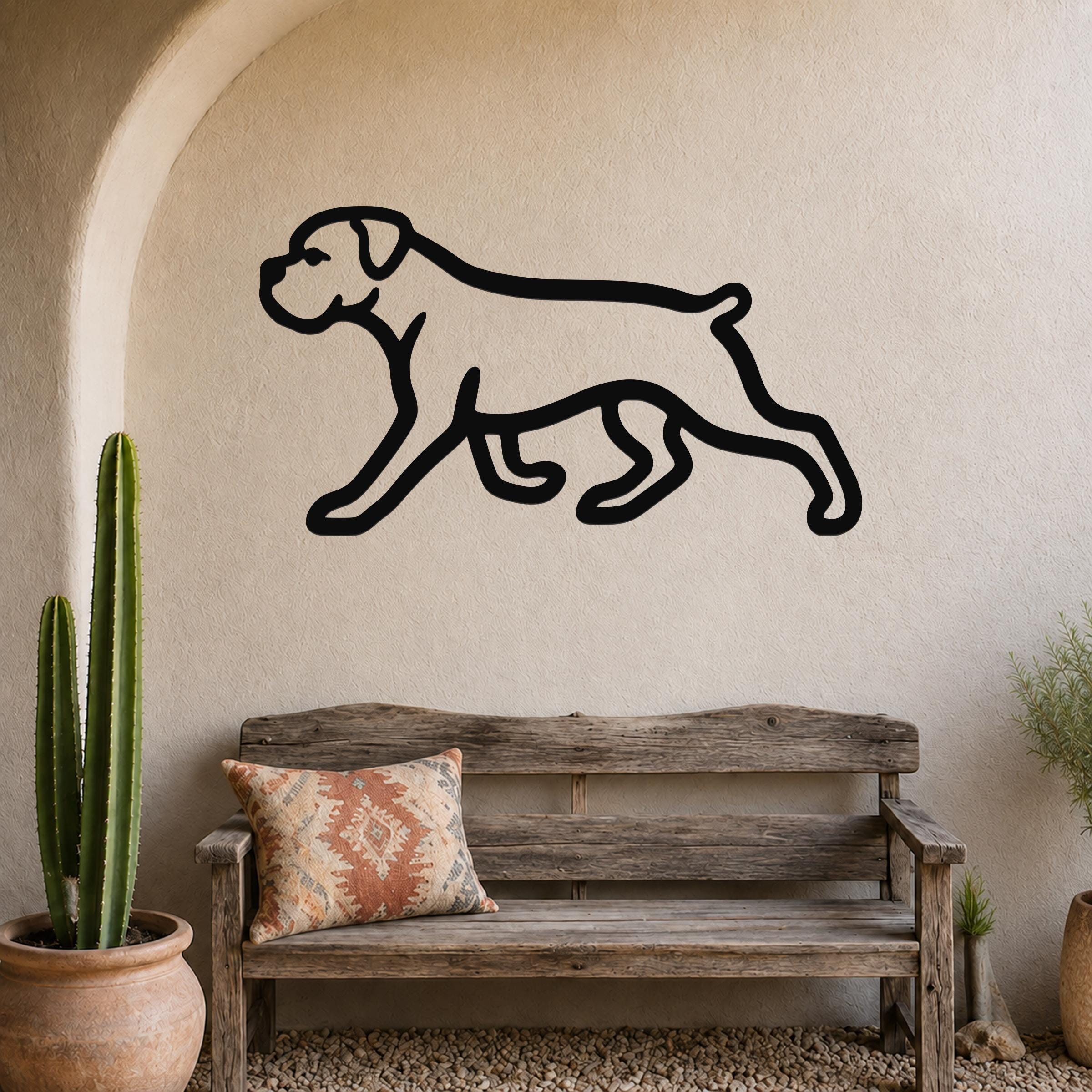 Black metal Boxer dog silhouette wall art mounted on a stucco wall above a wooden bench in a rustic patio setting.