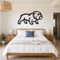 Black metal bulldog wall art silhouette mounted above a wooden bed in a bedroom.