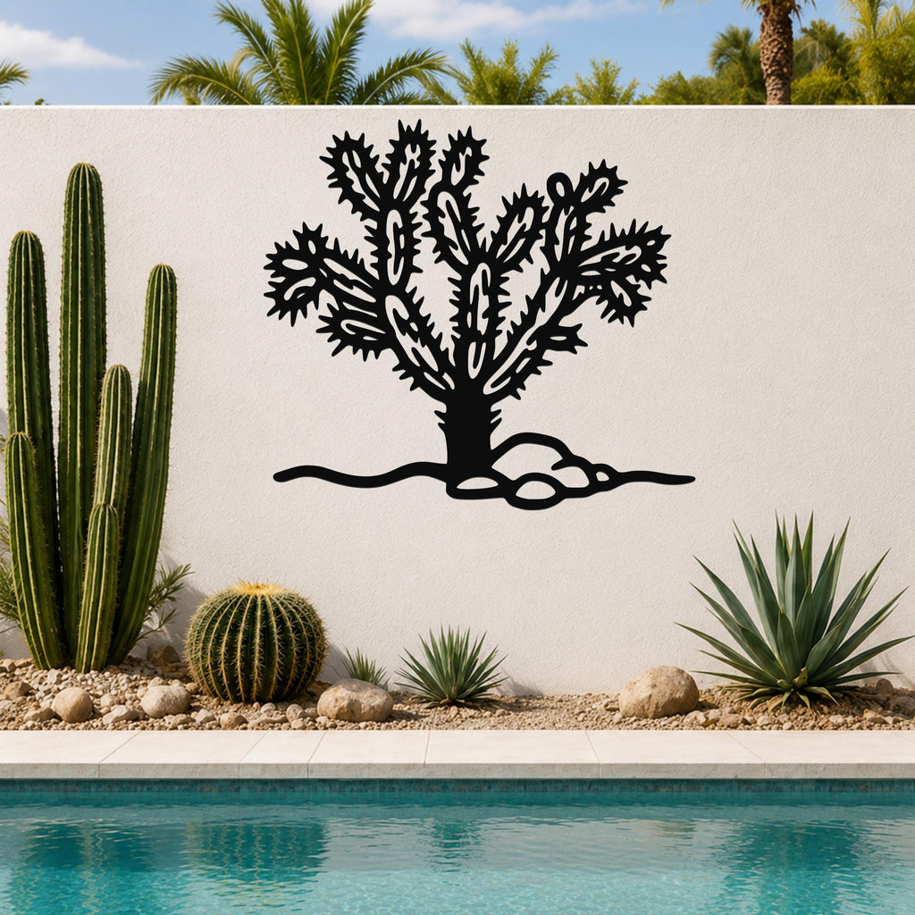 Black metal Cholla cactus wall art with intricate branch cutouts, mounted on a white outdoor wall above a poolside garden.