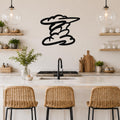 Black metal cloud wall art with flowing, layered cutouts, mounted on a kitchen wall above a counter with wicker bar stools.