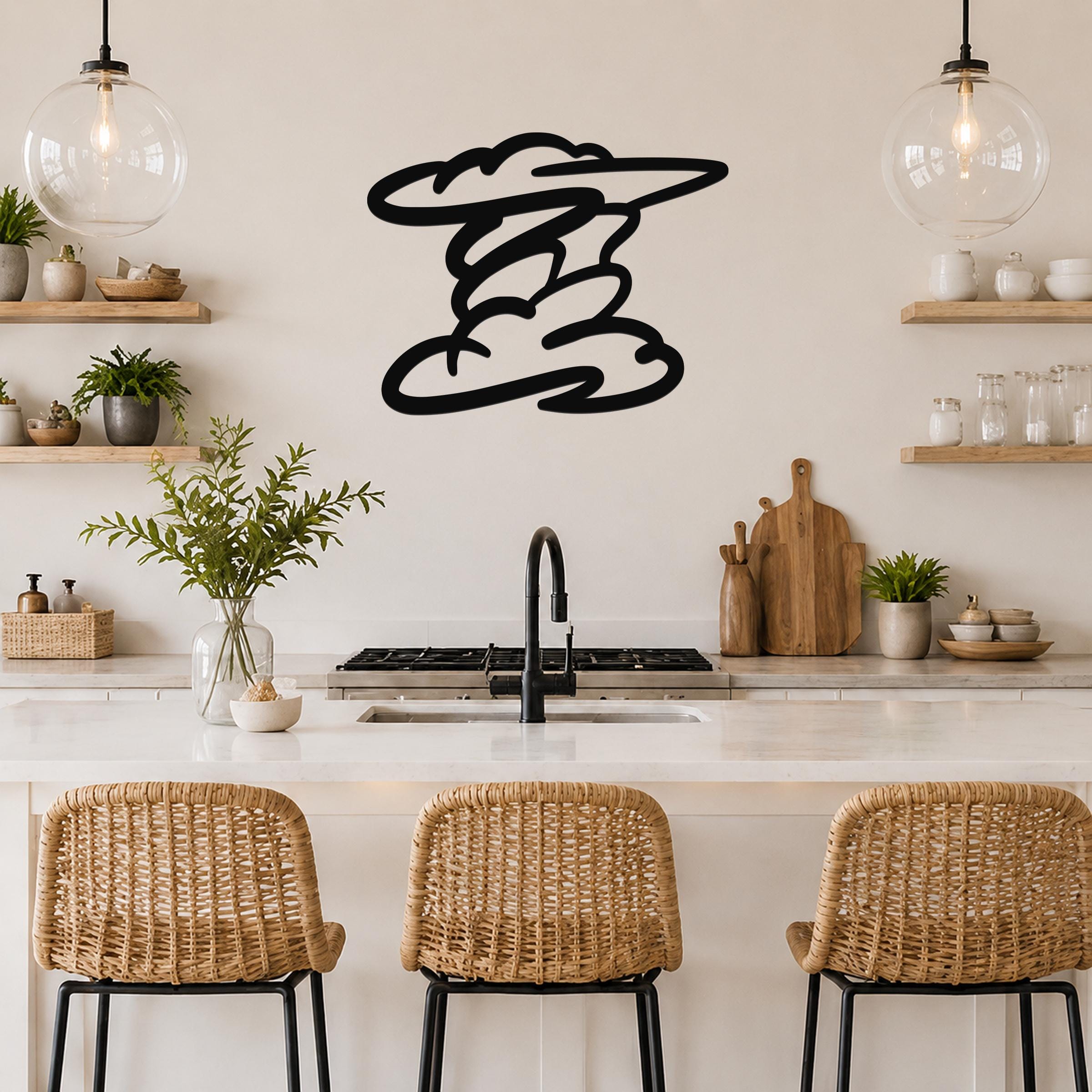 Black metal cloud wall art with flowing, layered cutouts, mounted on a kitchen wall above a counter with wicker bar stools.