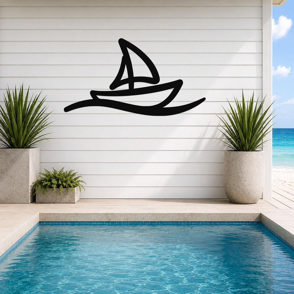 Black metal wall art in a sailboat silhouette with wave motion lines, mounted on a white shiplap wall above a pool in a coastal outdoor space.