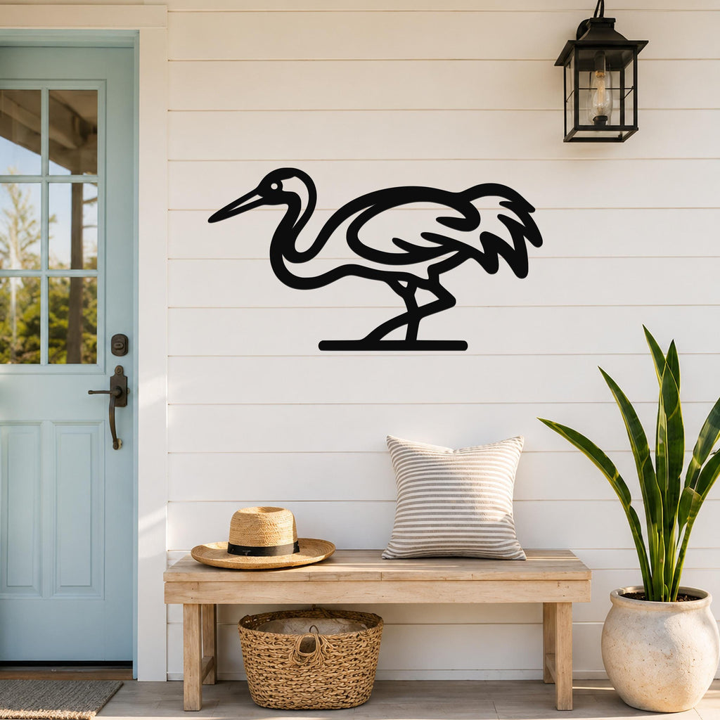 Black metal crane wall art with a minimalist silhouette design, mounted on a white shiplap wall above a wooden bench in a porch entryway.