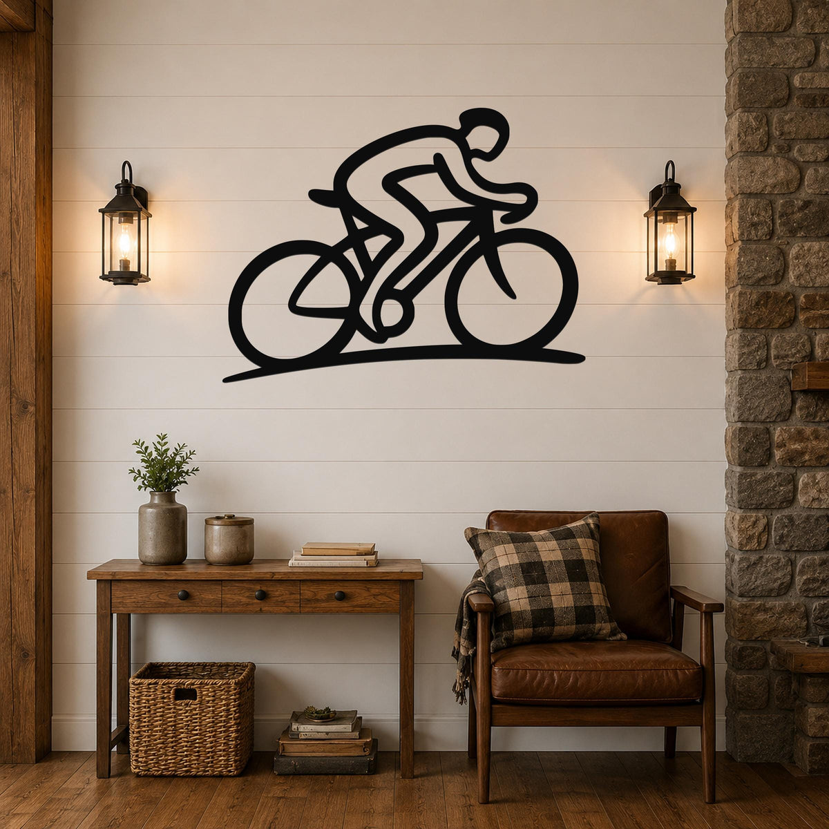 Black metal wall art featuring a cyclist silhouette in a dynamic riding pose, mounted on a shiplap wall above a wooden console table in a living room.