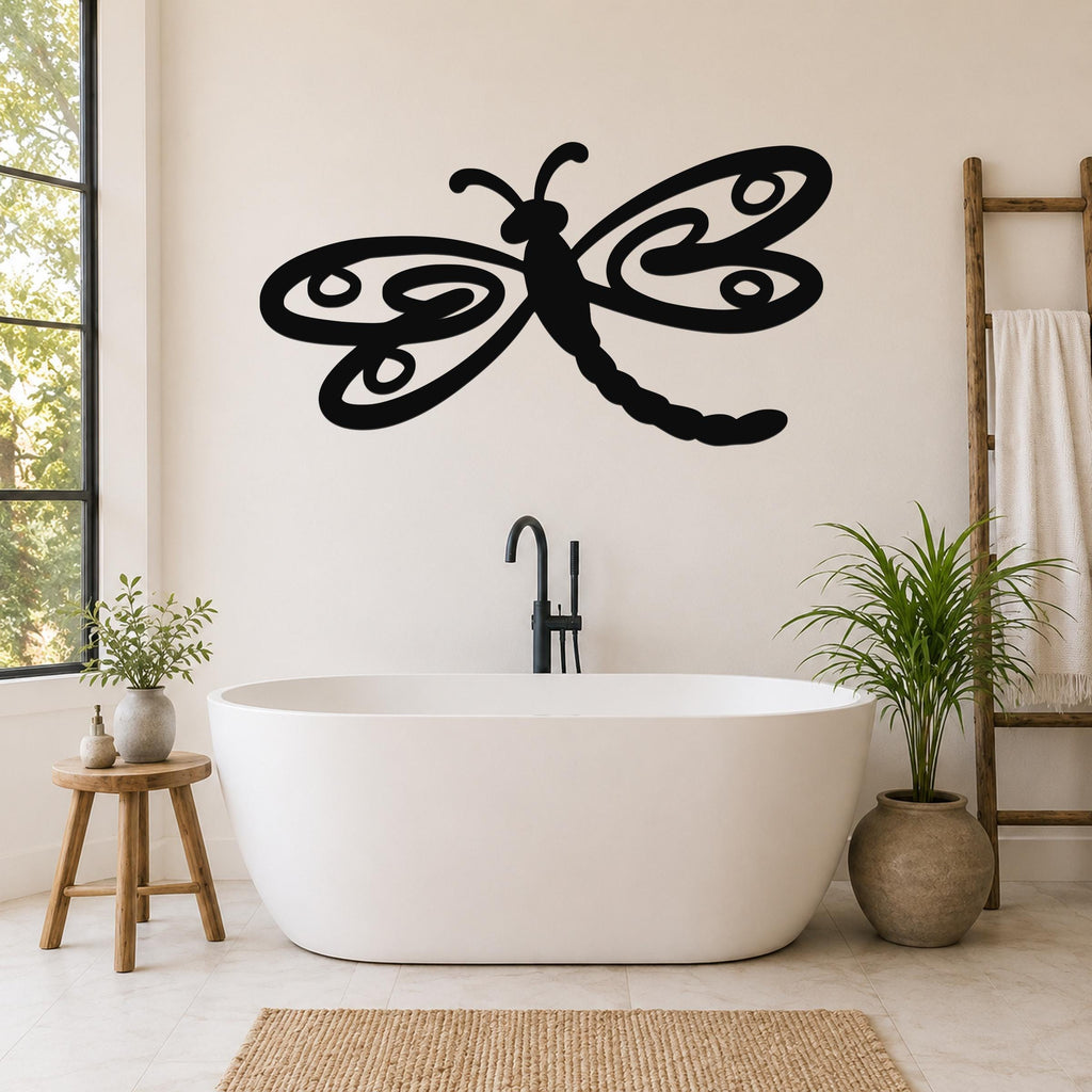 Black metal dragonfly wall art with intricate cutout wings, mounted on a bathroom wall above a freestanding tub.