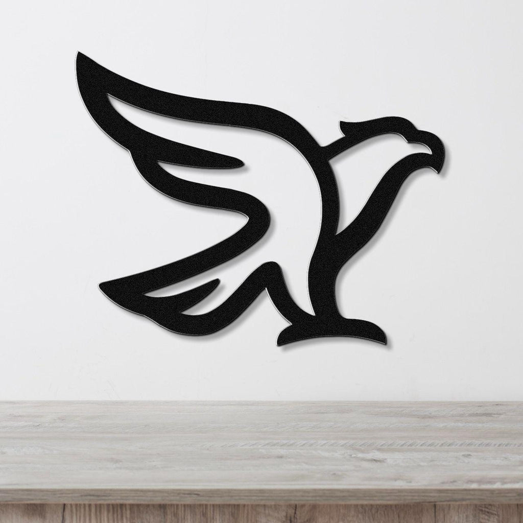 Black metal eagle wall art with a bold silhouette design, mounted on a white wall above a light wood surface.