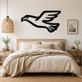 Black metal eagle wall art with a soaring silhouette, mounted above a bed in a neutral bedroom.