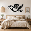Black metal eagle wall art with a bold silhouette and detailed wing feathers, mounted above a wooden bed in a neutral bedroom.