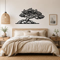 Black metal wall art of a juniper tree with intricate branch and leaf cutouts, mounted above a bed in a neutral bedroom.