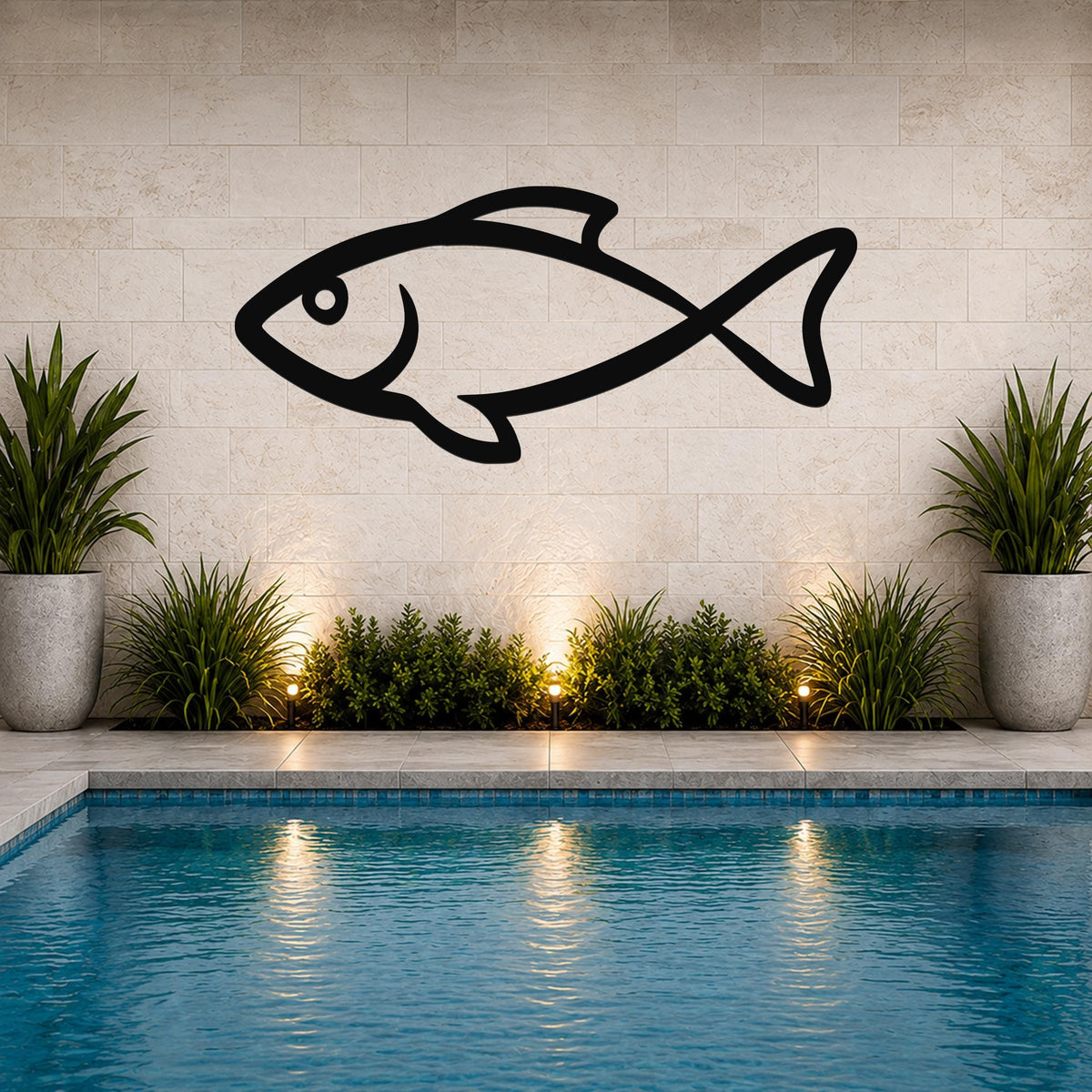 Black metal fish wall art silhouette mounted on a tiled outdoor wall above a pool, flanked by potted plants and illuminated by ground lights.