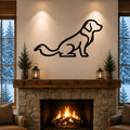 Black metal dog silhouette wall art of a sitting golden retriever, mounted above a stone fireplace in a living room with a snowy forest view.