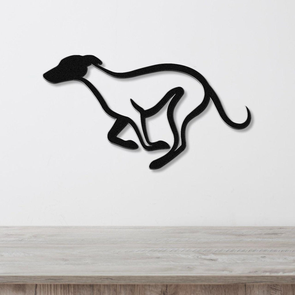 Black metal greyhound wall art with a sleek silhouette and internal cutout legs, mounted on a white wall above a light wood counter.