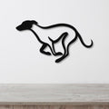 Black metal greyhound wall art with a sleek silhouette and internal cutout legs, mounted on a white wall above a light wood counter.