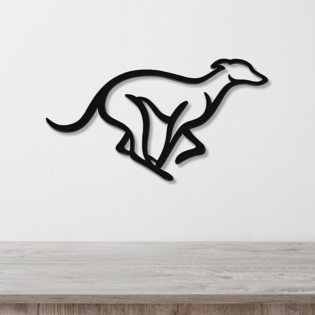 Black metal greyhound wall art with a sleek silhouette and internal cutout details, mounted on a white wall above a light wood surface.