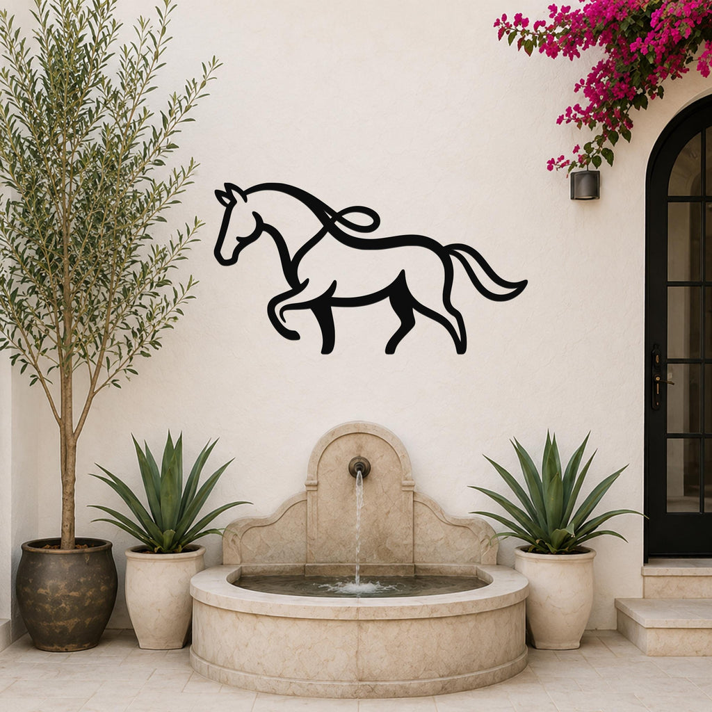 Black metal horse wall art with flowing mane and tail silhouette, mounted on a white outdoor wall above a stone fountain in a patio setting.