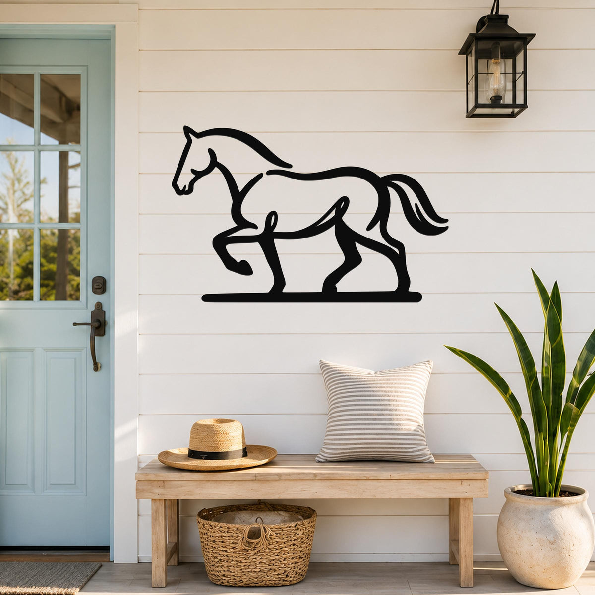 Black metal horse wall art silhouette with motion-line cutouts, mounted on a white shiplap wall above a wooden bench in a front entryway.