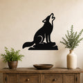 Black metal coyote wall art in a howling silhouette, mounted above a wooden console table with potted plants in a living room.