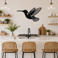 Black metal hummingbird wall art with wing and tail cutouts, mounted on a kitchen wall above a counter.