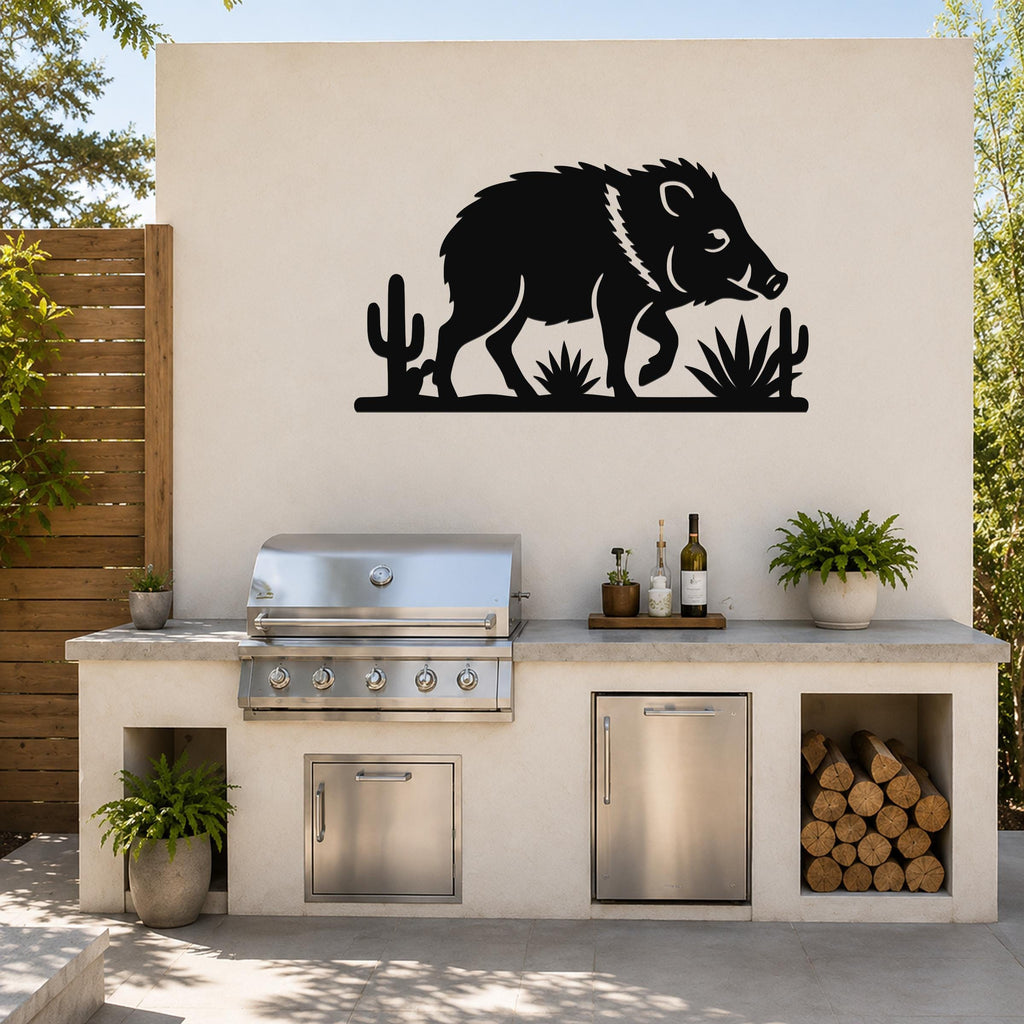 Black metal javelina wall art with cactus and agave cutouts, mounted on a beige outdoor wall above a kitchen counter.