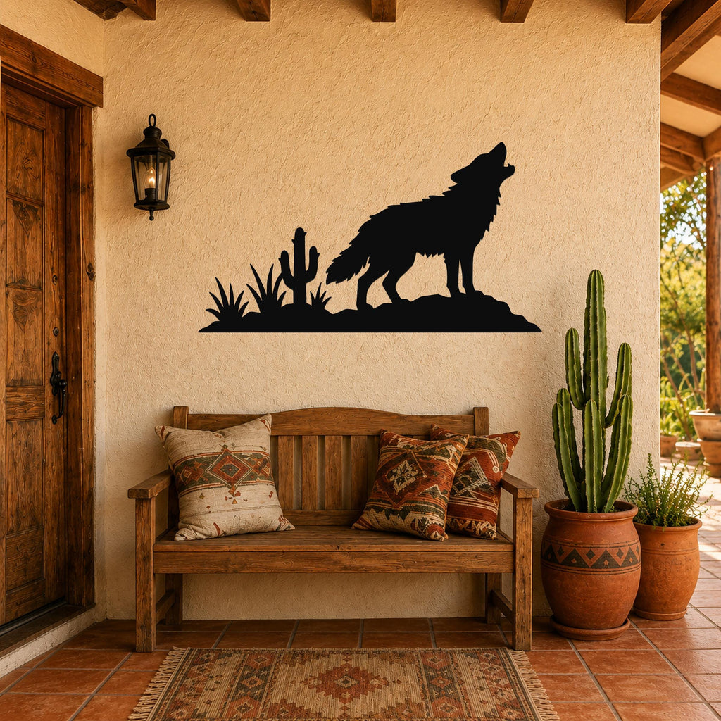 Black metal wall art silhouette of a coyote howling on a rock with cacti, mounted above a wooden bench on a stucco wall in a rustic patio setting.