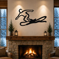 Black metal wall art of a snowboarder silhouette with motion-line cutouts, mounted above a stone fireplace in a living room.
