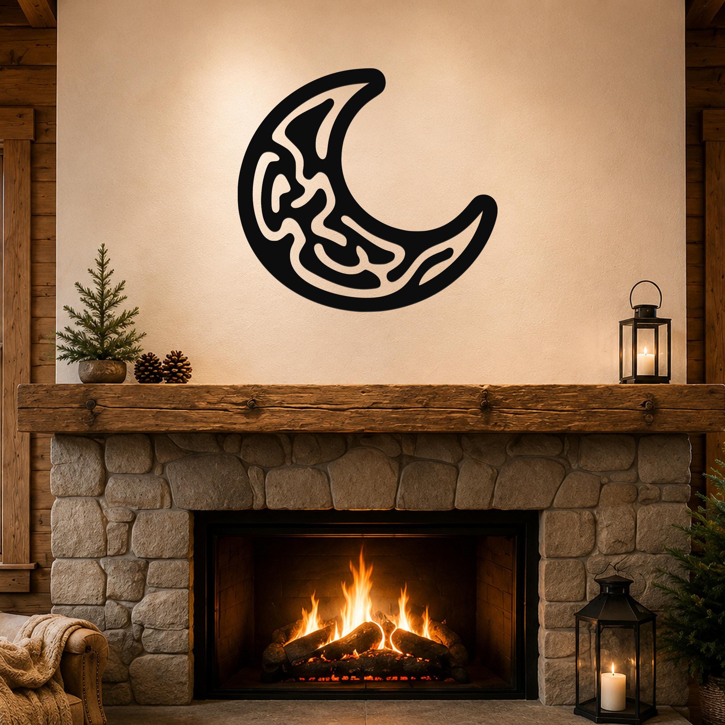 Black metal crescent moon wall art with intricate internal cutouts, mounted above a stone fireplace in a rustic living room.