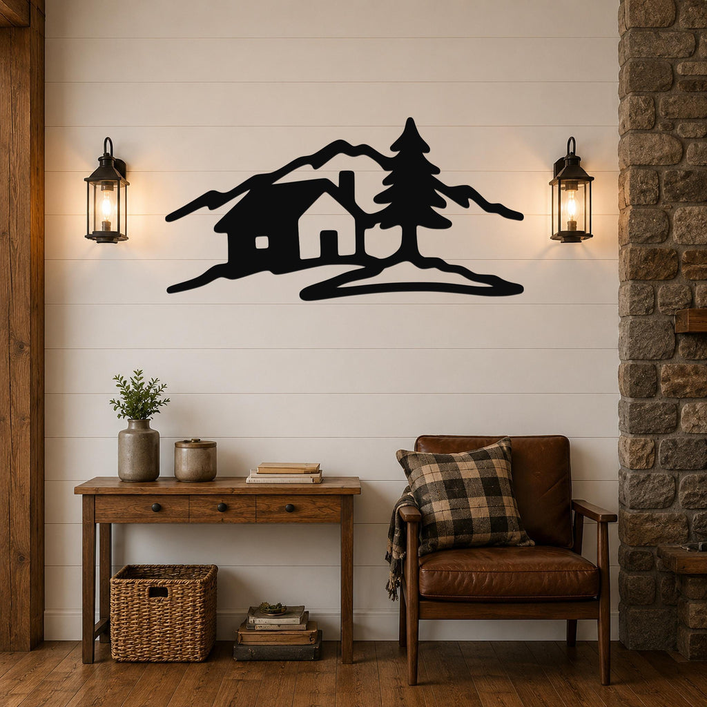 Black metal wall art silhouette of a cabin, pine tree, and mountains, mounted on a shiplap wall above a wooden console table in a living room.