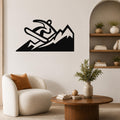 Black metal wall art featuring a snowboarder silhouette above mountain peaks, mounted on a living room wall above a white armchair.