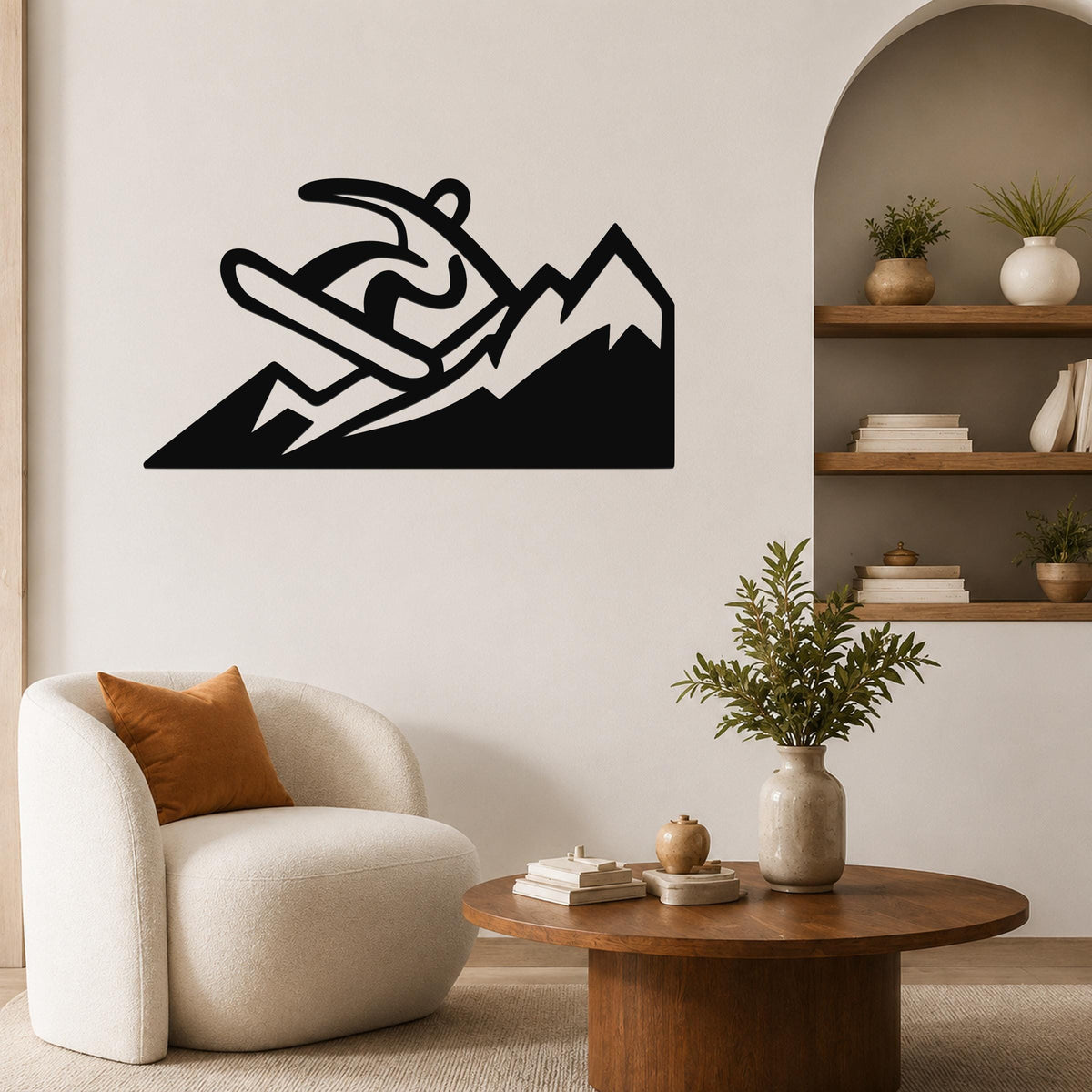 Black metal wall art featuring a snowboarder silhouette above mountain peaks, mounted on a living room wall above a white armchair.