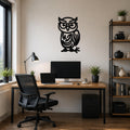Black metal wall art silhouette of a bespectacled owl with intricate internal cutouts, mounted on a wall above a wooden desk in a home office.