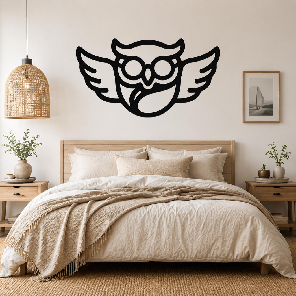 Black metal wall art silhouette of a bespectacled owl with spread wings, mounted above a bed in a neutral bedroom.
