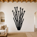 Black metal ocotillo wall art with spiny branch cutouts, mounted on a living room wall above a sofa.