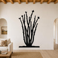 Black metal ocotillo wall art with branching stems and heart-shaped tips, mounted on a living room wall above a sofa.