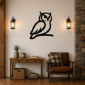 Black metal owl wall art silhouette mounted on a white shiplap wall above a wooden console table in a living room.